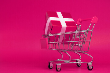 Pink Gift box in Shopping cart on Pink background - Love Valentine , birthday , or special thank...