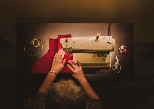 High angle view of woman using sewing machine at workshop