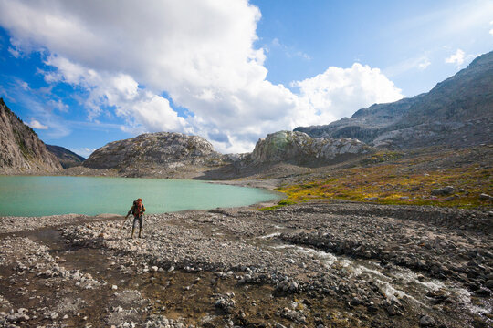 Full length of hiker standing on lakeshore at Garibaldi Provincial Park against sky