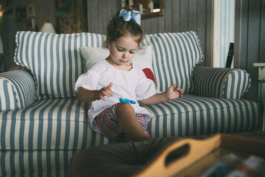 Cute girl playing with fidget spinner in living room at home