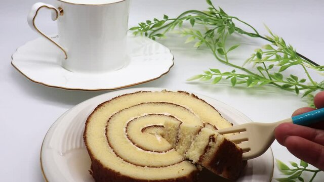 ロールケーキとティーカップ　フォークで持ち上げる