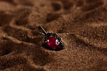 a precious piece of jewelry lying on a sandy beach