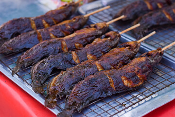 Grilled catfish on a wooden stick