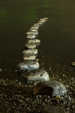 Row of rocks in river at riverbank