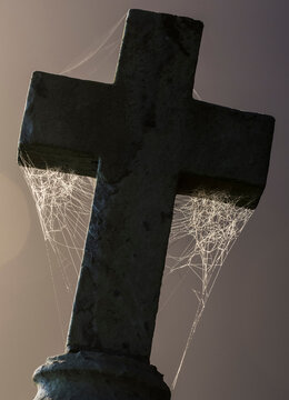 Low angle view of spider webs on cross against sky at night