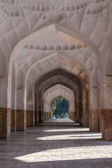 Beautiful perspective view of row of aligned arches around mughal emperor Jahangir's tomb in Char Bagh garden, Lahore, Punjab, Pakistan with side light