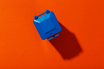 Blue trash can on an orange background. Infection control concept. Space for text.