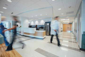 Doctor sitting at reception while hospital staff working