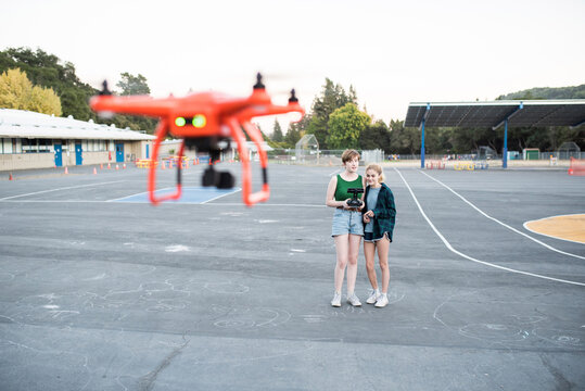 Teenage friends flying quadcopter at park