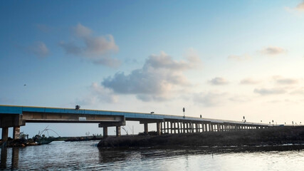 Obraz premium Concrete bridge cross the sea with sunset background.