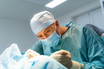 Naklejka premium Surgeon in operation room. Working with surgical instruments. Modern equipment in operating room.