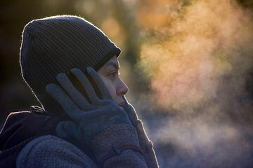 Close-up of woman exhaling breath vapor at park during winter