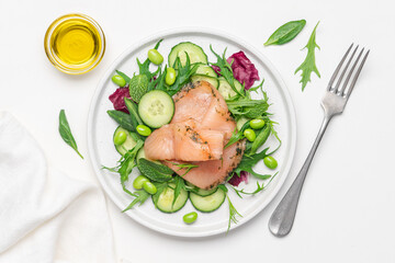 Salmon salad with cucumber, spinach, mizuna salad, radicchio. Healthy food, diet. Salted salmon in modern plate on white background 