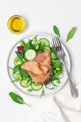 Salmon salad with cucumber, spinach, mizuna salad, radicchio. Healthy food, diet. Salted salmon in modern plate on white background 