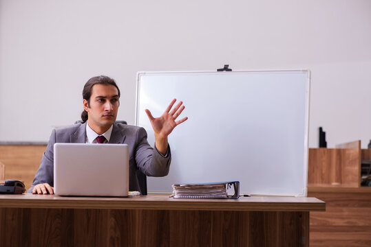 Young male business trainer in the office during pandemic
