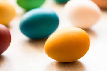 Yellow, red, orange, blue and green easter eggs painted with organic dyes on a grey table. Traditional Easter. Easter concept. Minimalism. Selective focus. 