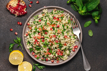 Tabbouleh salad with couscous, tomato, mint, parsley and pomegranate seeds. Traditional Middle Eastern cuisine 