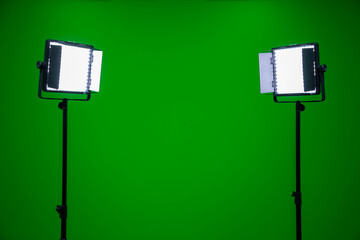Green screen television studio with two fill lights. Lights are on in chroma studio