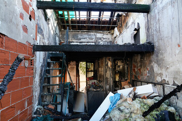 Burnt home room interior with walls house furniture and floor in ash and coal ruined old building after fire