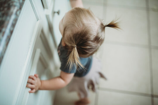 High angle view of girl with pigtails standing by cabinets in kitchen