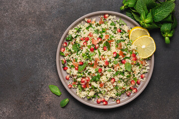 Tabbouleh salad with couscous, tomato, mint, parsley and pomegranate seeds. Traditional Middle Eastern cuisine 