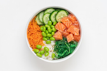 Poké bowl with fresh salmon, rice, chukka salad, edamame beans, carrots and cucumber. Bowl of healthy food on white background 