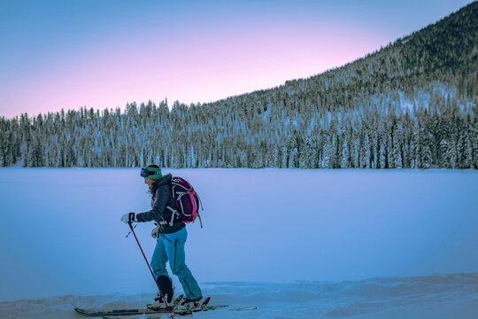 Tired female skier walking on snow covered field