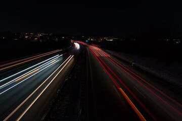 Fototapeta na wymiar Befahrene Autobahn mit Langzeitbelichtung aufgenommen in einer dunklen, kalten Nacht mitten in Deutschland.