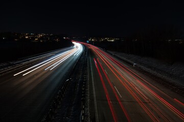 Fototapeta na wymiar Befahrene Autobahn mit Langzeitbelichtung aufgenommen in einer dunklen, kalten Nacht mitten in Deutschland.