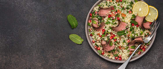 Tabbouleh salad with couscous and chopped beef steak on top. Traditional Middle Eastern cuisine 