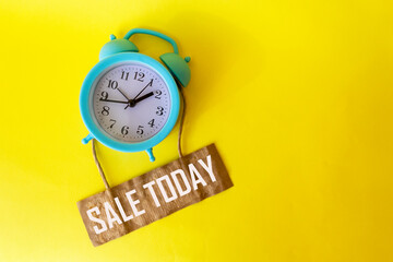 SALE TODAY is written on the tag and on a yellow background, there is an alarm clock nearby