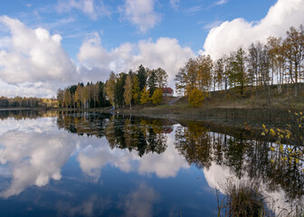Fototapeta premium colorful autumn panoramas with yellow trees by the lake, beautiful and colorful reflections in the calm lake water, golden autumn
