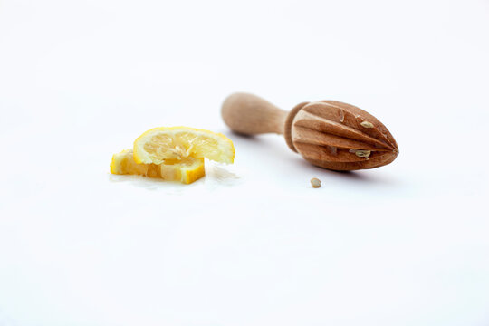 Lemon slices with wooden reamer on white background