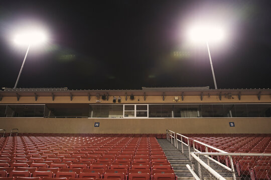 Low angle view of empty seats at illuminated American football stadium