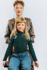 portrait of single mother and her daughter against white background