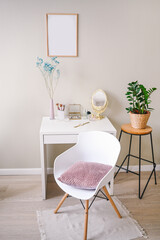 Minimalistic female still life workplace interior pastel colors. White table chair empty poster mock up frame, stylish fashion accessories golden mirror. Home plant in eco wicker flower pot. Template