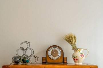 still life of antique clock with floral jug and silver stainless steel wine rackk with bottles