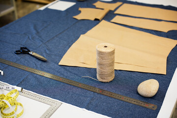High angle view of fabric with thread spool on table at workshop