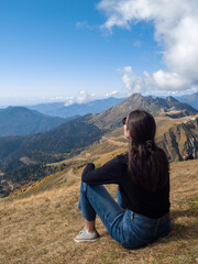 Fototapeta na wymiar Young female tourist sitting and enjoying the beautiful nature. Hiking in national parks,