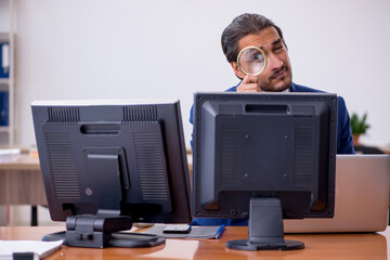 Young male employee in multitasking concept