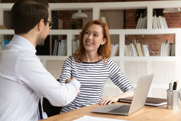 Smiling Caucasian diverse employees shake hands get acquainted greeting at meeting in office. Happy businesspeople handshake close deal make agreement at negotiation. Partnership concept.