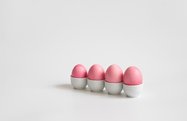 Easter minimal composition with pink eggs in stand on a white background. Easter concept. Copy space. Easter card.