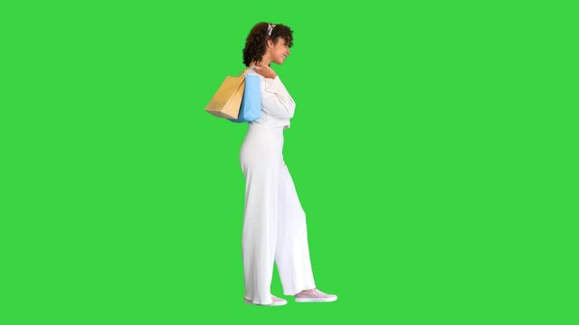 Young black lady carrying shopping bags on a Green Screen, Chroma Key.