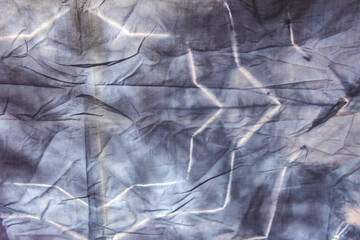 abstract pattern background of colorful traditional shibori tie dyed fabric with crumple creases and wrinkles 