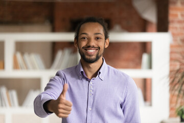 Naklejka premium Portrait of smiling African American male client or customer show thumb up give recommendation. Happy young mixed race ethnicity man feel satisfied recommend good quality service or company.