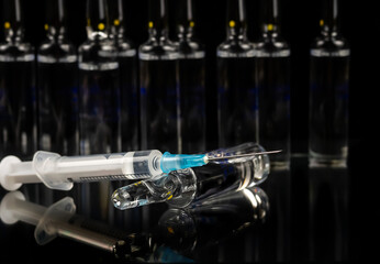 Ampoules and syringe on a black background.