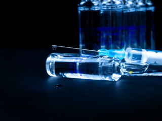 Ampoules and syringe on a black background.