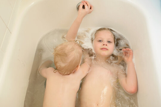 Portrait of sister with brother bathing in bathtub at home
