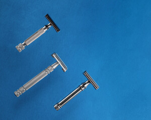 three razors on blue background. View from above.