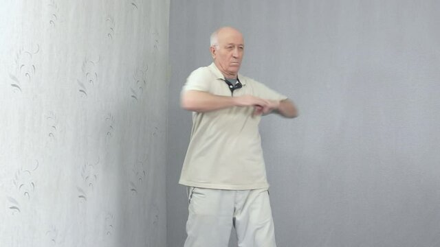 Old man in sportswear doing back warm-up